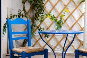 a blue table with a vase on it next to two chairs at Patras Centre Apartment in Patra
