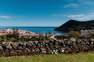 a town with a stone wall and the ocean at Casa do Becco in Angra do Heroísmo