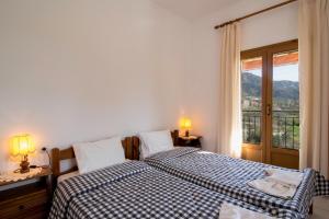 コルフ・タウンにあるVilla Blue Pearl Corfuのベッドルーム1室(ベッド2台付)、景色を望む窓が備わります。