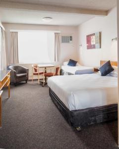 una camera d'albergo con due letti e un tavolo di Katoomba Town Centre Motel a Katoomba