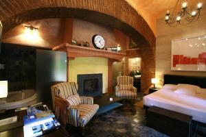 une chambre d'hôtel avec un lit et une cheminée dans l'établissement Hotel Boutique Palacio de la Serna, à Ballesteros de Calatrava