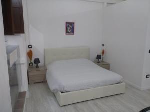 um quarto branco com uma cama e duas mesas de cabeceira em B&B da Bibi em Fabriano