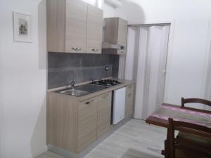 a small kitchen with a sink and a stove at B&B da Bibi in Fabriano