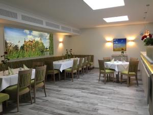 a dining room with tables and chairs and a painting on the wall at Das FRITZ Hotel Schwerin schöne Lage im Grünen mit regionaler Küche kostenfreien Parkplätzen und E Ladestation in Schwerin