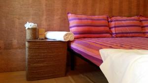 a bed with a pillow and a table with a towel at Ceylon Antheia Beach Resort in Nilaveli +58 photos