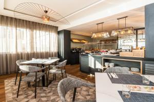 a restaurant with tables and chairs and a kitchen at Eurostars Marivent in Palma de Mallorca