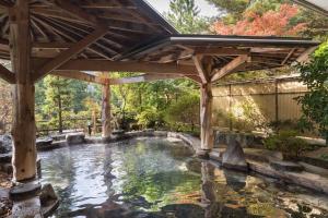 a pool of water with a wooden pergola at Hotel Koyokan in Hanamaki