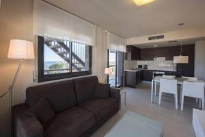 a large living room with a couch and a kitchen at Tropicana Planet Costa Dorada in Cambrils