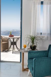 a living room with a table and a blue chair at Anteliz Suites in Fira