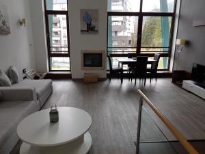 a living room with a couch and a table at Silver Poiana Brasov Ap 41 in Poiana Brasov