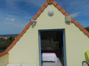 Cette petite maison blanche dispose d'une fenêtre et d'un lit. dans l'établissement Hôtel Le Vivier WISSANT - Vue Mer - Côte d'Opale - Baie de Wissant - 2CAPS, à Wissant