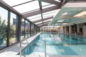 a swimming pool in a building with windows at Résidence Neptunia in Saint Malo