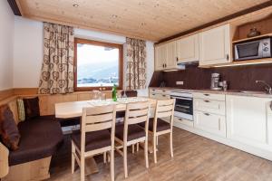 a kitchen with a table and chairs and a window at Apart Tyrol in Uderns