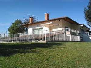 una casa con una valla blanca y una sombrilla en Bed and Breakfast Villa Sofia, en Ponzano Veneto