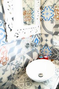 a bathroom with a sink and a mirror and tiles at Relais Villa Italia in Selcetta