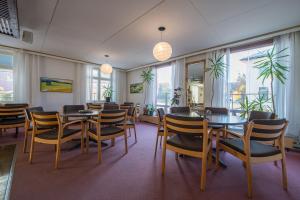 jadalnia ze stołami, krzesłami i oknami w obiekcie Kokemäen Seurahuone w mieście Kokemäki