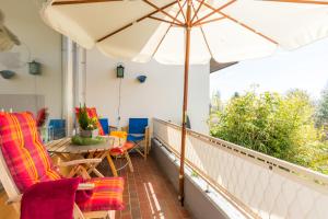 a balcony with a table and chairs and an umbrella at Ferienwohnung Seesucht in Gaienhofen
