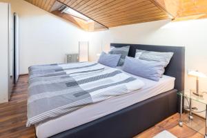 um quarto com uma cama grande com lençóis azuis e brancos em Ferienwohnung Seesucht em Gaienhofen