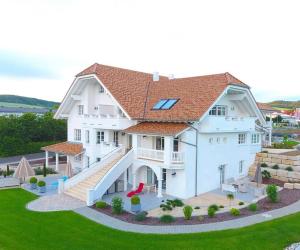 ein großes weißes Haus mit einem Dach in der Unterkunft Belle Maison - Das kleine Hotel in Werbach