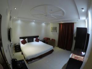 a bedroom with a bed and a chair in it at Masat Al Badr Furnished Apartments in Medina