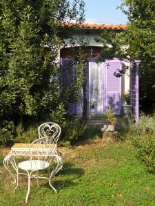 un banco blanco sentado frente a una casa púrpura en Cuore Verde, en Cavour