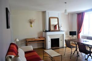 a living room with a couch and a table and a mirror at Petite Roche gîtes centre-ville La Rochelle in La Rochelle