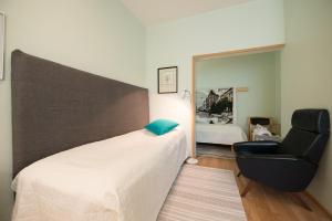 a bedroom with a bed and a chair and a mirror at Kokemäen Seurahuone in Kokemäki