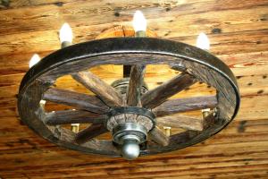 a wooden wagon wheel chandelier hanging from a ceiling at City Center Apartments in Poltava