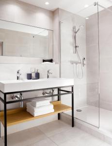 La salle de bains est pourvue d'un lavabo et d'une douche. dans l'établissement One Loft Appart, à Obernai