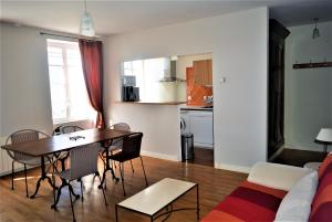 ein Wohnzimmer und eine Küche mit einem Tisch und Stühlen in der Unterkunft Petite Roche gîtes centre-ville La Rochelle in La Rochelle