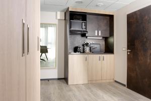 a kitchen with wooden cabinets and a microwave at One Loft Appart in Obernai