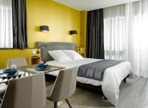 a bedroom with a bed and a table with chairs at One Loft Appart in Obernai