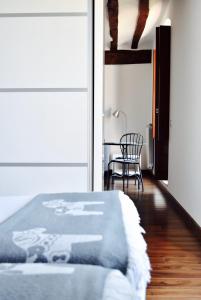 a bedroom with a bed and a table and a chair at Apartamentos Turísticos Rincones del Vino in Ezcaray