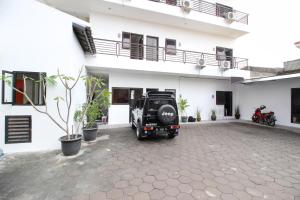 a vehicle parked in front of a white building at RedDoorz Plus @ Affandi Gejayan in Yogyakarta