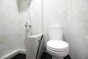 a bathroom with a toilet and a shower at RedDoorz Plus @ Affandi Gejayan in Yogyakarta +9 photos