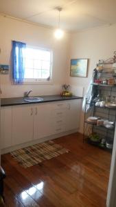a kitchen with a counter and a sink and a window at Monday Seaside Cottage in Whanganui