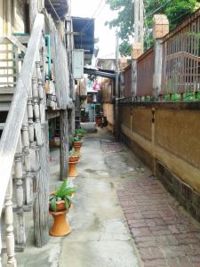 an alley with potted plants on the side of a building at Ray Nu Guest House in Phra Nakhon Si Ayutthaya +74 photos