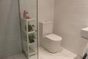 a bathroom with a toilet and a glass shower at Exquisite Family Home +Parking, Close to CBD in Sydney +26 photos