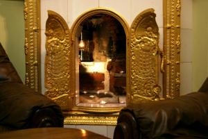 a gold mirror on a wall next to a table at City Center Apartments in Poltava