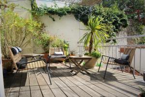 eine Terrasse mit Stühlen, einem Tisch und einem Zaun in der Unterkunft Petite Roche gîtes centre-ville La Rochelle in La Rochelle