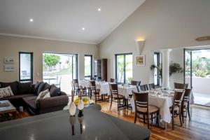 a dining room with white tables and chairs at Orange Inn Knysna in Knysna