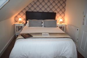 a bedroom with a large bed with two night stands at The Tables Guest House in Dunvegan