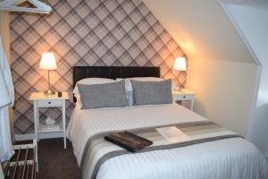 1 dormitorio con 1 cama grande y 2 mesitas de noche en The Tables Guest House, en Dunvegan