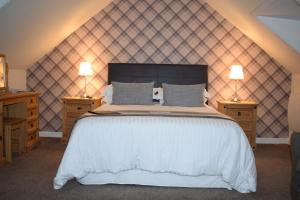 a bedroom with a large white bed with two night stands at The Tables Guest House in Dunvegan