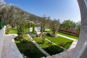 a view of a garden with trees and grass at Townhouse Virginia in Petrovac na Moru