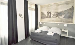 een slaapkamer met een bed en een schilderij aan de muur bij DAC50 Luxurious apartment Domburg in Domburg