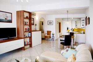 ein Wohnzimmer mit einem weißen Sofa und einem Esszimmer in der Unterkunft Apartments Visnja in Vodice