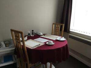 a table with a red table cloth and two chairs at Ingleneuk Bed and Breakfast in Edinburgh