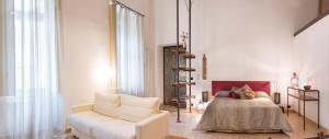 sala de estar con cama y sofá blanco en Il Salottino di Torino - Loft di charme e storia, en Turín