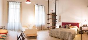 ein Schlafzimmer mit einem Bett und einem Stuhl in einem Zimmer in der Unterkunft Il salottino in via Carlo Alberto in Turin